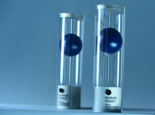 Bild von zwei PUNKT Trophäen. Sie sind Zylinderförmig und enthalten einen großen blauen Ball.